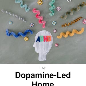 Puede incluir: Vista cenital de limpiapipas rizados de colores y pequeñas decoraciones en forma de flor sobre una superficie gris. Un contorno blanco de una cabeza contiene la palabra "ADHD" en letras coloridas. El texto "The Dopamine-Led Home" y "ADHD Systems That Actually Stick" está debajo.
