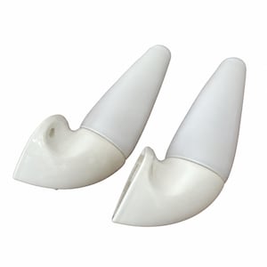 Può includere: Una coppia di applique da parete bianche con base curva lucida e paralume conico in vetro satinato. Ogni lampada presenta una silhouette liscia e arrotondata con un foro di montaggio visibile sul lato per il fissaggio diretto alla parete.