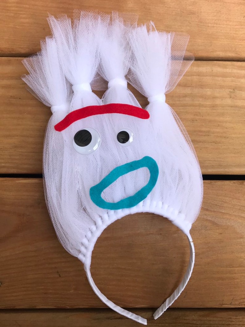May include: White tulle headband with a red, white, and blue felt face. The face has googly eyes, a blue mouth, and a red eyebrow.