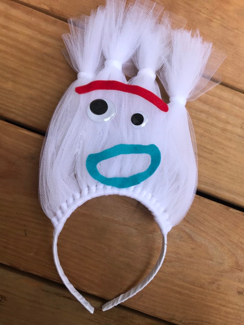 May include: White tulle headband with a felt face, red eyebrows, googly eyes, and a turquoise mouth.