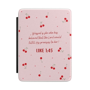 Op de afbeelding: Een roze hoesje met een patroon van rode kersen en de tekst "Blessed is she who has believed that the Lord would fulfill His promises to her!" en "LUKE 1:45". De hoes heeft een zwarte rug.
