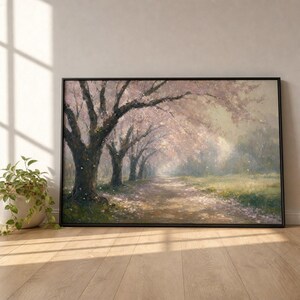 May include: A rectangular framed wall art print depicting a landscape with a dirt path lined by large trees with dark trunks and light pink blossoms. The scene features soft, hazy light filtering through the branches, creating a gentle atmosphere.