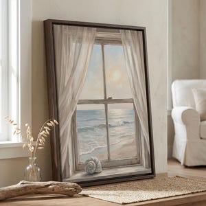 May include: A framed canvas art piece depicts a coastal scene. The artwork shows a window with sheer curtains, overlooking a beach and ocean. A seashell rests on the window sill. The frame is dark brown.