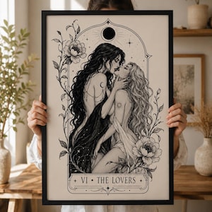 May include: Black framed art print featuring a black and white illustration of two women embracing. The artwork includes floral elements, celestial details, and the text "VI • THE LOVERS." The print has a vintage aesthetic.