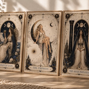 Puede incluir: Juego de tres impresiones enmarcadas de cartas del tarot con ilustraciones detalladas. Las cartas están etiquetadas como "Queen of Cups", "The Empress" y "The High Priestess". Cada impresión tiene una estética vintage con elementos celestiales y florales, en tonos beige, azul y dorado.