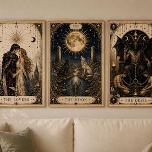 Puede incluir: Conjunto de tres impresiones enmarcadas de cartas del tarot. Las impresiones presentan ilustraciones detalladas de las cartas "Los Amantes", "La Luna" y "El Diablo". Cada carta tiene un diseño único con elementos góticos y celestiales, en estilo vintage.