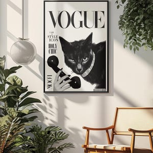 Puede incluir: Portada de la revista Vogue en blanco y negro con un gato negro con collar de perlas y un auricular de tel&eacute;fono. La portada incluye el logotipo de Vogue y las frases "I AM STYLE ICON" y "HOLY CHIC". La imagen est&aacute; enmarcada y colgada en una pared blanca.