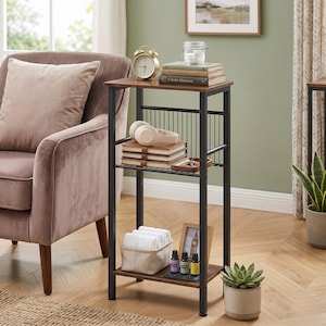 May include: A small, brown and black side table with three shelves. The top shelf holds a gold alarm clock, books, and a glass jar. The middle shelf has headphones and books. The bottom shelf has a basket, picture frame, and essential oil bottles.
