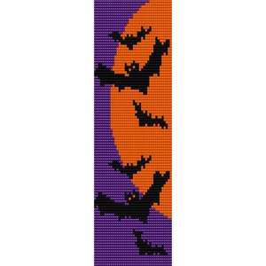 May include: A purple and orange beaded bookmark with a design of bats flying in front of a setting sun.