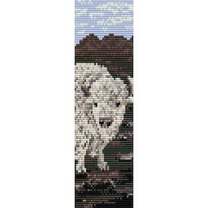 May include: A white bison with brown eyes stands in a field of green grass with a brown mountain in the background.