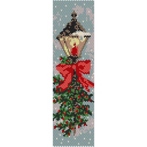 May include: A beaded Christmas ornament featuring a lamppost with a red bow and green holly. The lamppost is decorated with a red cardinal and a white snowy cap. The background is a light blue with white snowflakes.