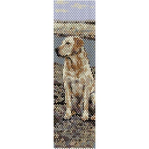 May include: A beaded pattern of a golden retriever dog sitting on a rocky beach. The dog is looking to the left of the image. The background is a blue sky with white clouds.