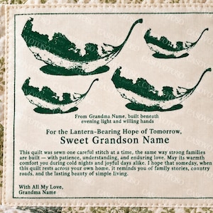 May include: A cream-colored fabric label sewn onto a green and white floral patterned quilt. The label features dark green leaf illustrations and printed text including 'For the Lantern-Bearing Hope of Tomorrow, Sweet Grandson Name' and a poem.