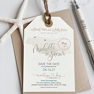 May include: A save the date wedding invitation with a luggage tag design. The tag is decorated with a watercolor-style illustration of Jamaica. The text reads "Sandy toes and salty kisses" and "Michelle & Junior". The date of the wedding is 04.16.21 and the location is Montego Bay, Jamaica. The invitation also includes the name of the hotel, Hyatt Ziva Rose Hall, and contact information for travel inquiries.