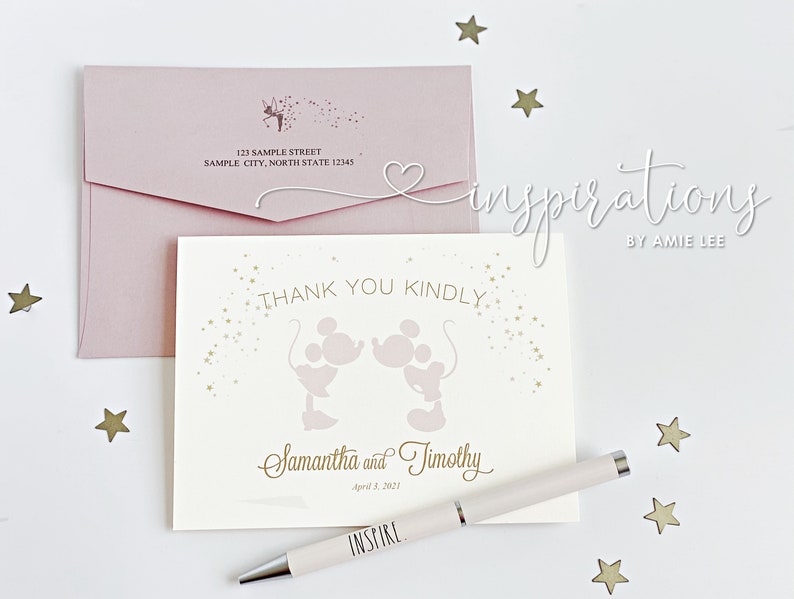 Puede incluir: Una tarjeta de agradecimiento rosa p&aacute;lido con siluetas de Mickey y Minnie Mouse, texto dorado y un sobre a juego. La tarjeta dice "Thank You Kindly" y est&aacute; personalizada con nombres y una fecha. Tambi&eacute;n hay un bol&iacute;grafo con "INSPIRE".