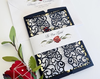 May include: A black and gold wedding invitation with a laser cut design. The invitation features a red rose and the text "Be Our Guest".