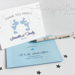 Puede incluir: Una tarjeta blanca plegada con siluetas azules de Mickey Mouse y el texto "THANK YOU KINDLY". Un sobre azul claro y un bol&iacute;grafo con la palabra "INSPIRE" tambi&eacute;n est&aacute;n presentes. La tarjeta est&aacute; personalizada.