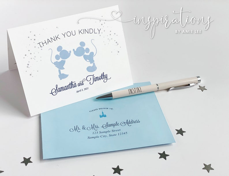 Puede incluir: Una tarjeta blanca plegada con siluetas azules de Mickey Mouse y el texto "THANK YOU KINDLY". Un sobre azul claro y un bol&iacute;grafo con la palabra "INSPIRE" tambi&eacute;n est&aacute;n presentes. La tarjeta est&aacute; personalizada.