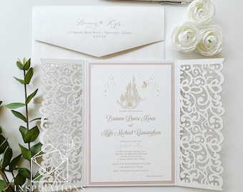 May include: Elegant wedding invitation suite featuring a laser-cut design and a Disney castle illustration. The invitation includes the names Brianna and Kyle, along with event details. A pen and white flowers are also present.