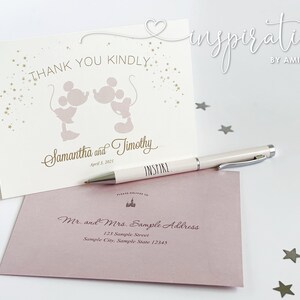 Puede incluir: Juego de papeler&iacute;a de boda marfil con una tarjeta con siluetas de Mickey y Minnie Mouse y el texto "Thank You Kindly". Incluye un sobre y un bol&iacute;grafo con la palabra "INSPIRE".