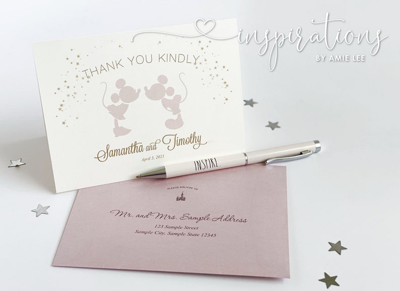Puede incluir: Juego de papeler&iacute;a de boda marfil con una tarjeta con siluetas de Mickey y Minnie Mouse y el texto "Thank You Kindly". Incluye un sobre y un bol&iacute;grafo con la palabra "INSPIRE".