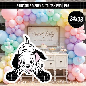 May include: A printable cutout of a spotted puppy character positioned in front of a party display featuring a pastel balloon arch, a wooden sign reading Sweet Baby WELCOME LITTLE ONE, and a white cabinet with treats and a cake.