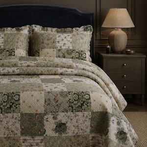 May include: A patchwork quilt and two matching pillow shams featuring a repeating grid of squares in muted shades of sage green, cream, and dusty rose. The fabric squares display various floral patterns, intricate damask prints, and striped motifs.