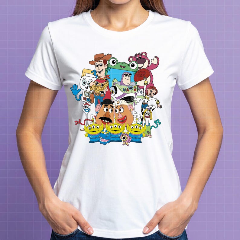 May include: White t-shirt with a vibrant graphic of Toy Story characters, including Woody, Buzz Lightyear, and the Little Green Men. The design is a colourful illustration of the animated film's characters. The t-shirt is made of a soft, lightweight fabric.