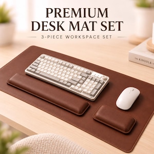 May include: A brown desk mat set featuring the text PREMIUM DESK MAT SET 3-PIECE WORKSPACE SET. The set includes a large rectangular brown desk mat, a long brown wrist rest for a keyboard, and a smaller brown wrist rest for a computer mouse.
