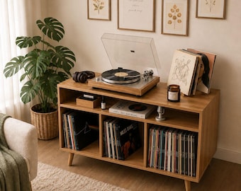 May include: A wooden record player console with a turntable, records, and framed botanical prints. The console has multiple compartments filled with vinyl records. A potted plant and a cozy rug complete the scene.