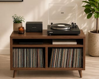 May include: A mid-century modern style media console in a warm brown finish. It features a record player, a speaker, and storage for vinyl records. A small potted plant and a candle are also on the console.