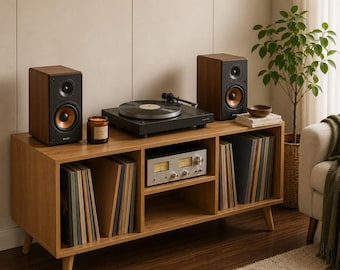 May include: A wooden media console with four storage compartments containing vinyl records and a silver audio receiver. On top sits a black turntable, two wooden speakers with copper-colored cones, and a small candle in a glass jar.
