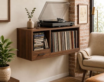 May include: A wall-mounted dark wood storage unit featuring a top surface holding a black record player, a small drawer with a black handle, a vertical compartment for cassette tapes, and a large open shelf filled with vinyl record albums.