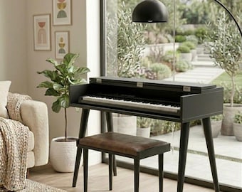 May include: A black digital piano with a hinged lid and a matching bench featuring a brown leather-look seat. The piano has a standard keyboard with black and white keys, supported by four tapered legs, positioned in a room with a large window.
