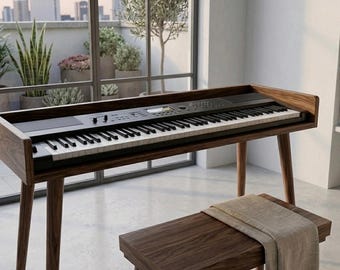 May include: A digital piano with a black keyboard and control panel housed in a dark wood frame with four tapered legs. A matching dark wood bench sits in front of the piano, draped with a folded light beige fabric cloth.