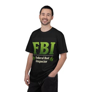 May include: Black t-shirt with the text "FBI Federal Bud Inspector" in green. The shirt features the acronym "FBI" in large, bold letters, with the full phrase below. Two green cannabis leaves flank the text.