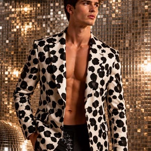 May include: A blazer featuring a white base with an all-over black abstract spot pattern, paired with black trousers that have a subtle silver floral embroidery detail and the text FOanding printed on the upper thigh area.