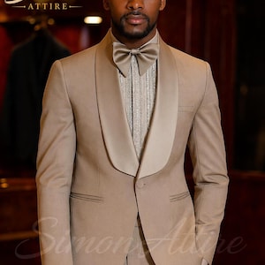 May include: A tan suit with a satin lapel and matching bow tie. The suit is worn over a textured, light-colored shirt. The image features the Simon Attire logo in gold script. The suit appears to be tailored and formal.