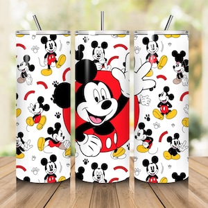 May include: Three stainless steel tumblers with a white background featuring a repeating pattern of Mickey Mouse in various poses. The central tumbler has a large Mickey Mouse design on a red circle. Each tumbler has a silver straw.