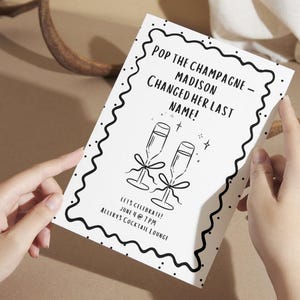 Puede incluir: Una tarjeta de invitación blanca con texto negro y un borde decorativo. La tarjeta dice "Pop the Champagne - Madison Changed Her Last Name!" con copas de champán ilustradas debajo. También se incluyen los detalles del evento.