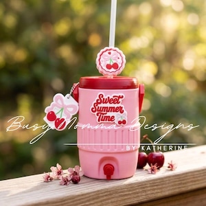 May include: Pink cooler with a red lid, featuring the text "Sweet Summer Time" and cherry accents. Includes a white straw and a cherry-shaped charm. Ideal for summer drinks.