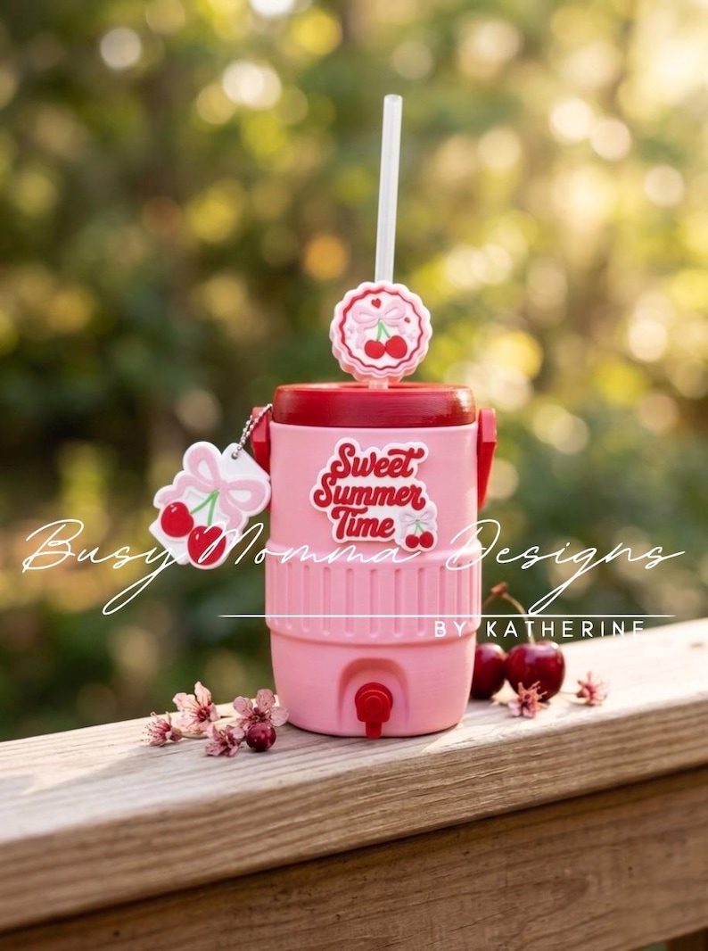 May include: Pink cooler with a red lid, featuring the text "Sweet Summer Time" and cherry accents. Includes a white straw and a cherry-shaped charm. Ideal for summer drinks.