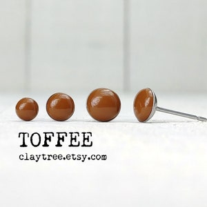 Puede incluir: Tres pares de pendientes de botón de arcilla marrón en diferentes tamaños. Los pendientes están sobre una superficie blanca. TOFFEE claytree.etsy.com