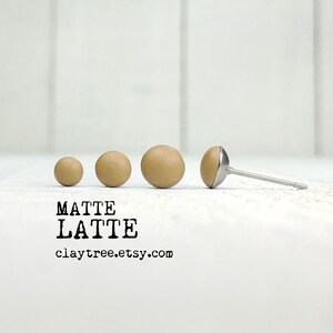 May include: Four matte brown clay earrings in different sizes, with a silver post and backing. The earrings are arranged in a line from smallest to largest. The text "MATTE LATTE claytree.etsy.com" is below the earrings.