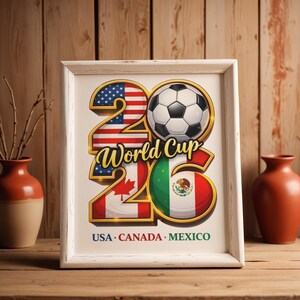 Pode incluir: Uma impress&atilde;o emoldurada com uma borda branca com uma bola de futebol e o texto "World Cup 26". Os n&uacute;meros "26" s&atilde;o projetados com as bandeiras dos EUA, Canad&aacute; e M&eacute;xico. O texto "USA CANADA MEXICO" est&aacute; na parte inferior.