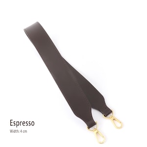 May include: Espresso-colored bag strap with gold-tone clasps. The strap is made of a smooth material and is 4 cm wide. The strap is designed to be attached to a bag.