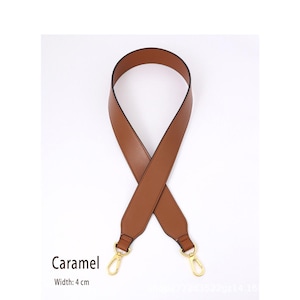 May include: A caramel-colored purse strap with gold-tone clasps. The strap is 4 cm wide and made of a smooth material. The word "Caramel" is printed on the image.