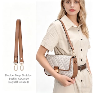 May include: A tan and white handbag with a brown leather strap and buckle. The bag features a repeating "MK" pattern. A separate brown leather shoulder strap with gold-coloured hardware is also shown. The text on the image reads "Shoulder Strap: 60x2.0cm | Buckle: 4.0x2.8cm (Bag NOT Included)".