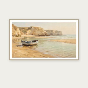 May include: A framed landscape painting depicts a serene coastal scene. A small, weathered boat rests on the sandy shore, with cliffs in the background. The water is a light turquoise color, and the sky is a pale yellow.