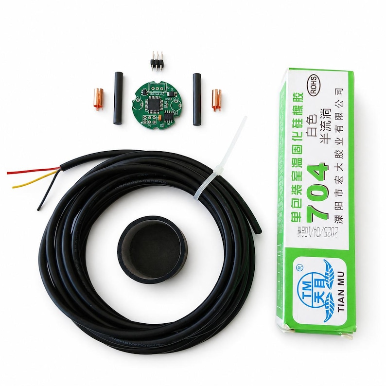 May include: An electronic component kit featuring a circular green circuit board, a long black cable with three exposed wires, two black cylindrical rods, two copper-colored connectors, a black circular cap, and a green tube of 704 silicone adhesive.